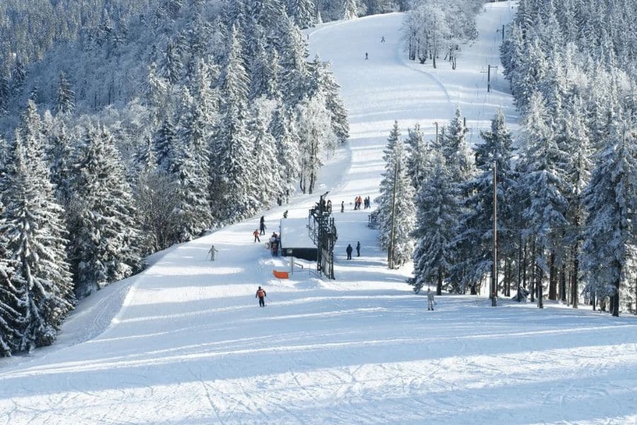 The French Ski Slopes in Winter covered in snow with people skiing