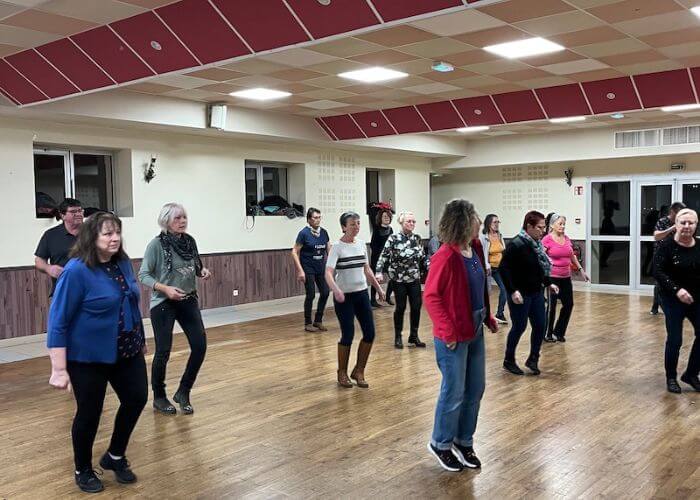 Line dancing group practicing in a room