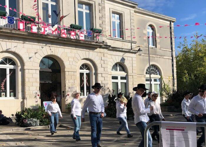 People line dancing in the town square in Ruffec France