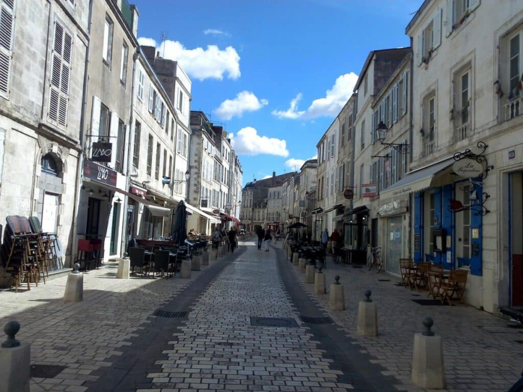 A street with buildings either side and a pedestrian path in the middle
