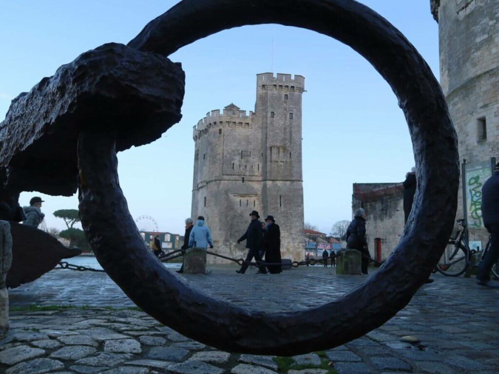 A large concrete tower silhoutted against an iron ring