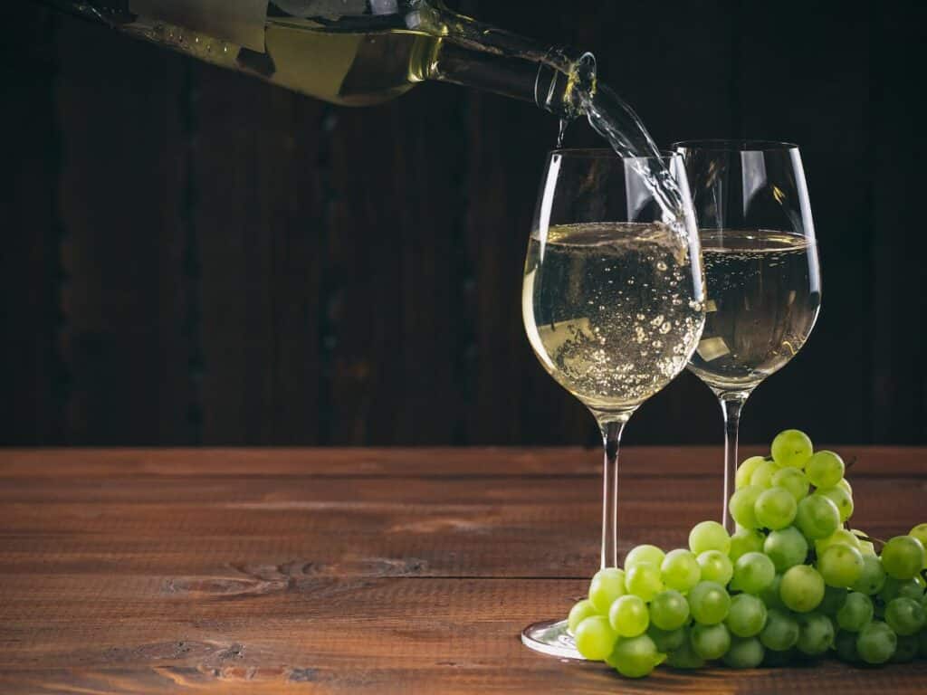 Two glasses of wine with some grapes