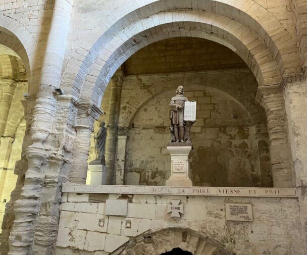A stone statue of a saint in a church in France