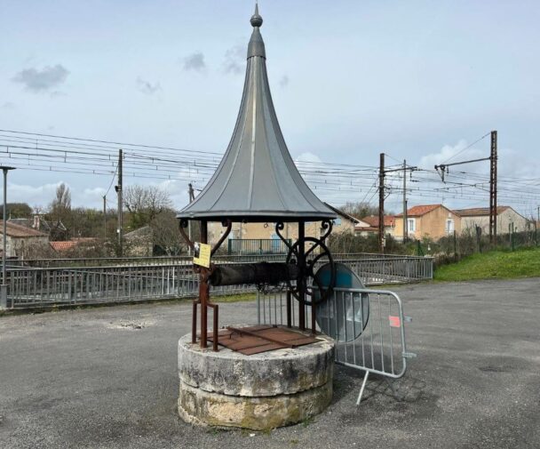 A stone well by a train station in a village in France