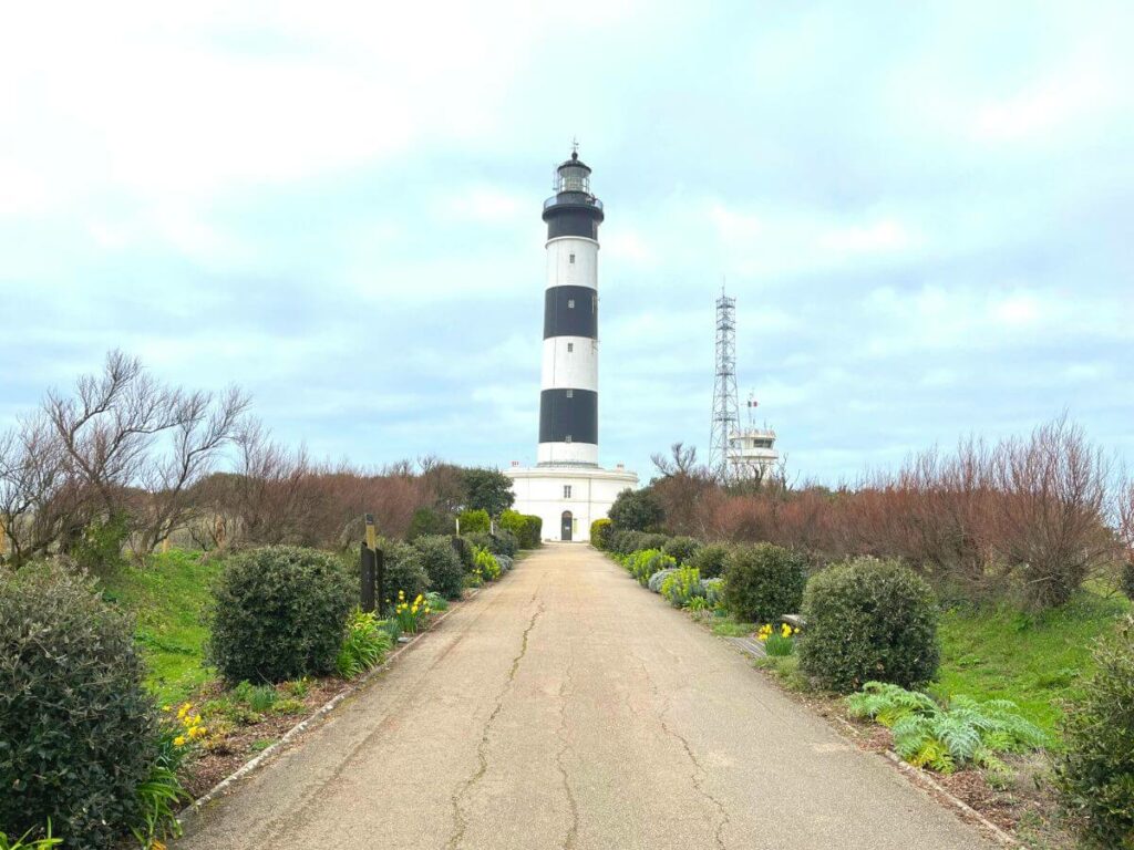 A black and white lighthouse against a blue sky