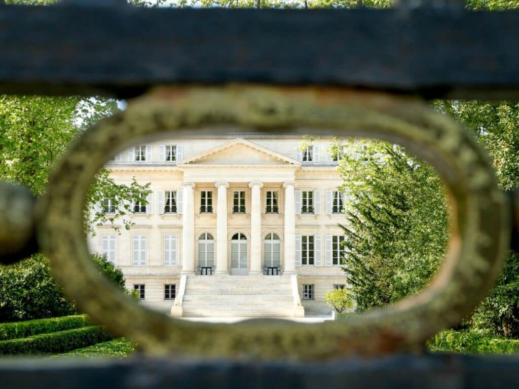 An old building in Bordeaux through a keyhole style green bush