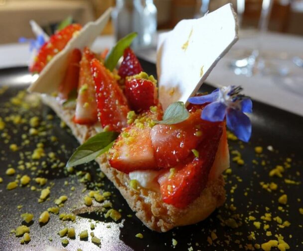 A gourmet dessert with strawberries nicely presented on a plate