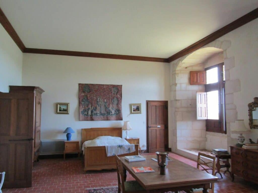 A bed and wardrobe in a basic bedroom at the Chateau de Bayers in the Charente
