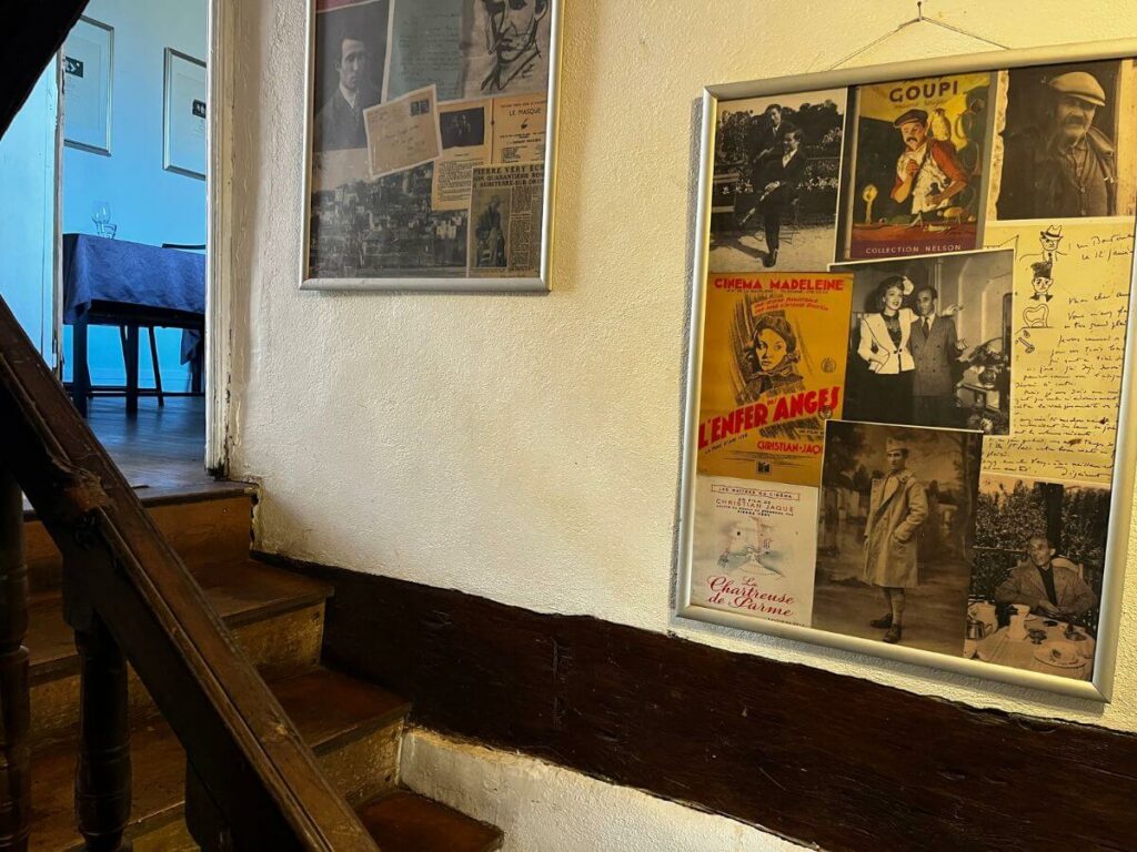 A wooden staircase with pictures on the wall of an hold house in Aubeterre-sur-Dronne