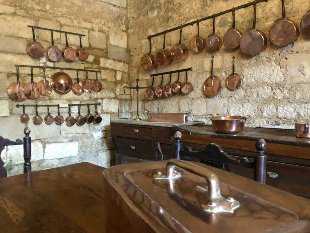 Rows of copper pots and pans hung up in the kitchen at the Chateau of Rochefoucauld