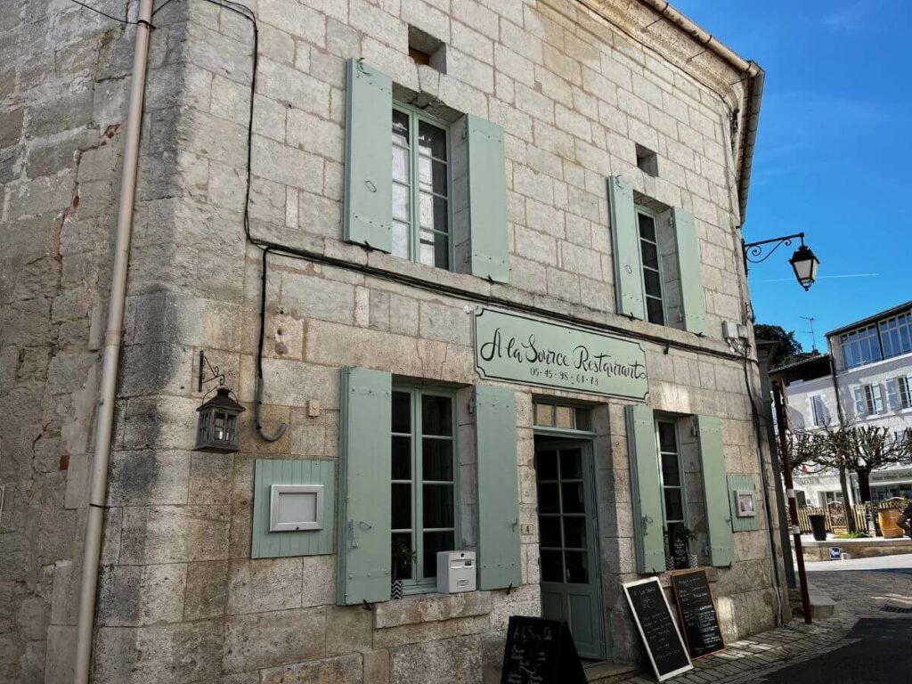 An old stone building with green shutters in Aubeterre-sur-Dronne