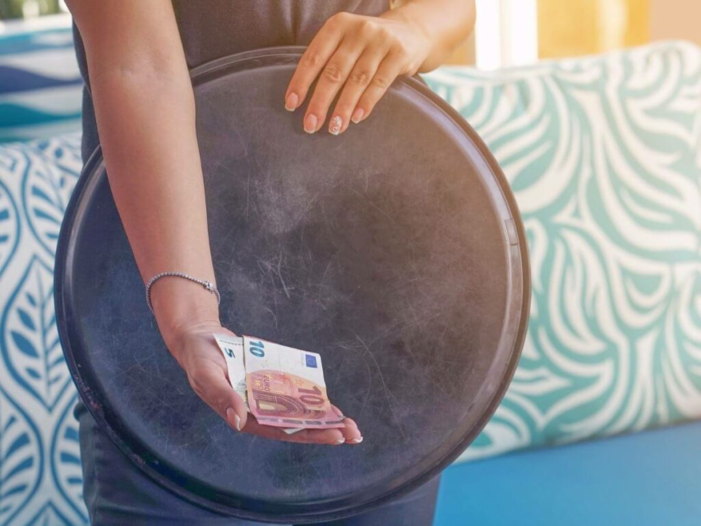 A woman holding a tray with some euro notes in her hand