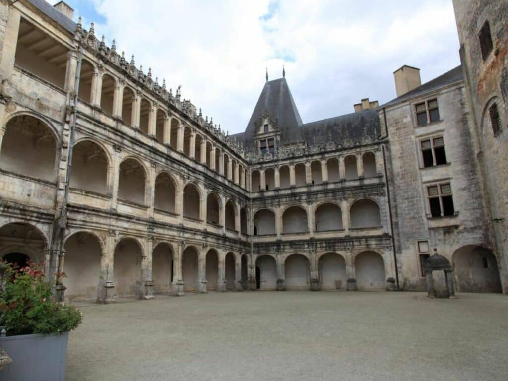 An old stone courtyard with three storeys at Chateau de la Rochfoucauld