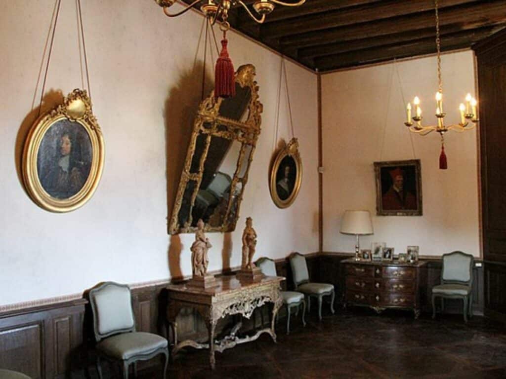 An old room with paintings and a mirror in the Chateau de la Rochefoucauld