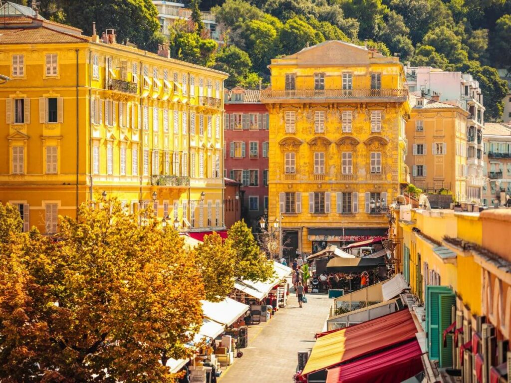 A street with yellow buildings hosting a French flower market