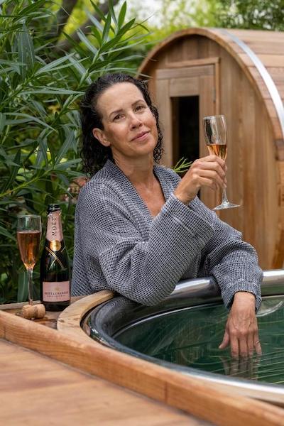 A woman with a glass of champagne standing by a hot tub