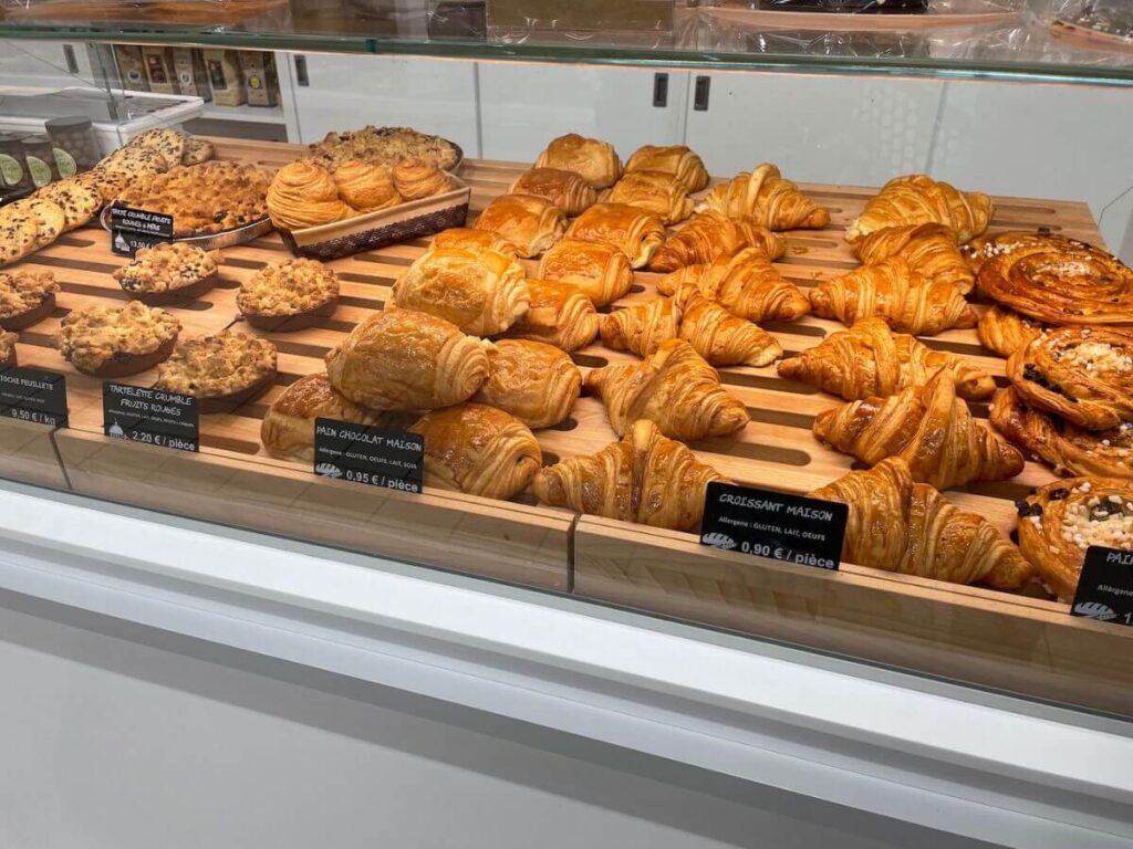 A patisserie counter in a French supermarket with croissants and pastries