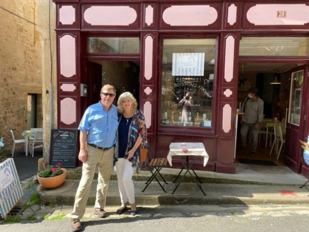 A couple outside a shop in an old French village