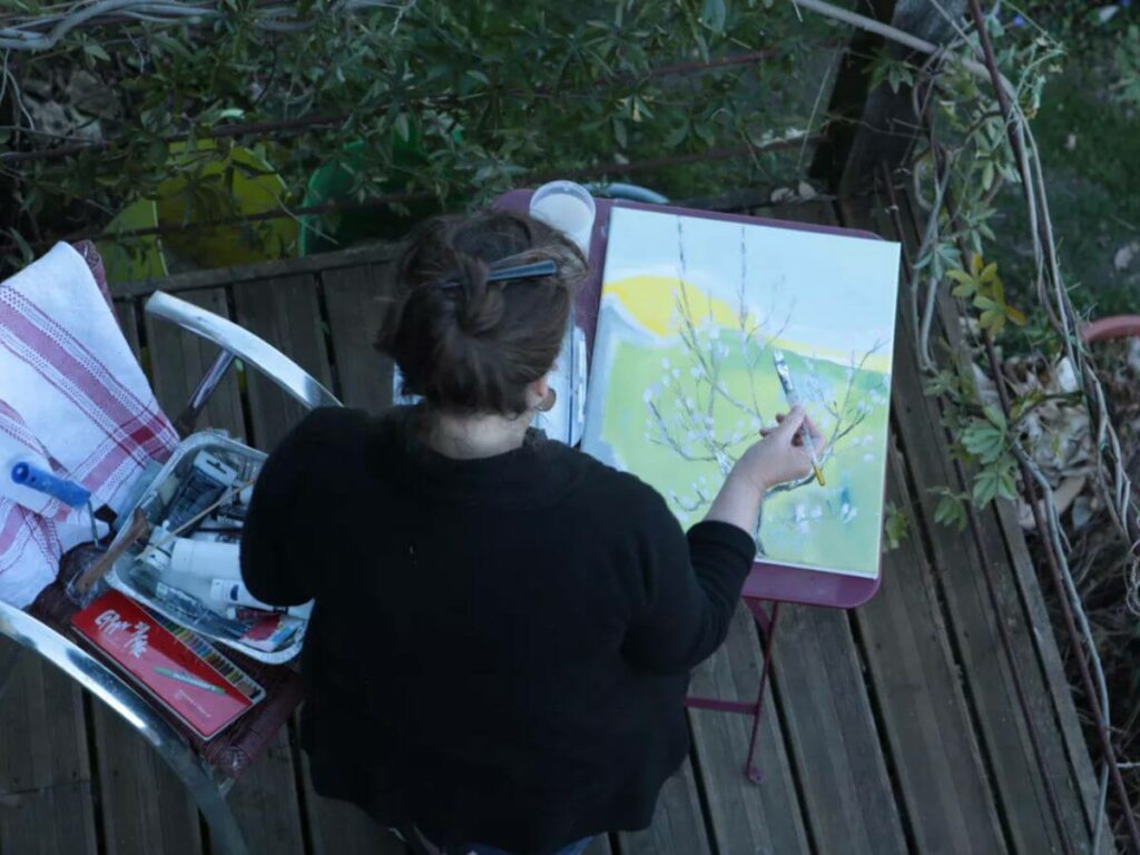 A woman painting in her artist studio in France