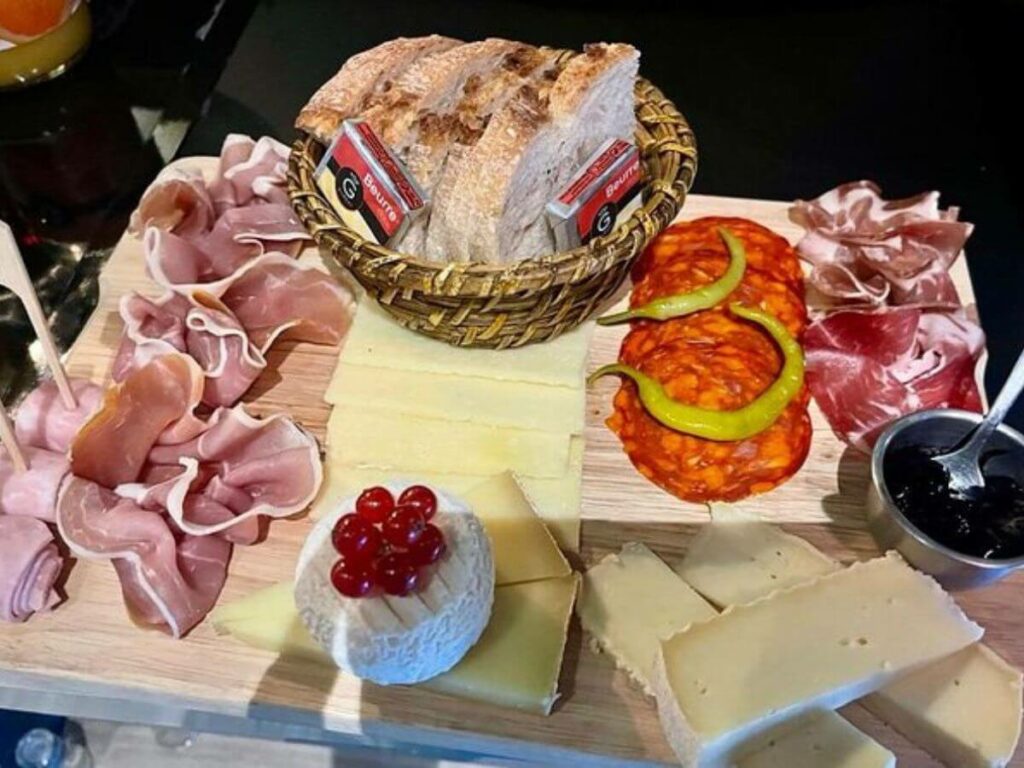 A chacuterie board with cured meats and cheeses