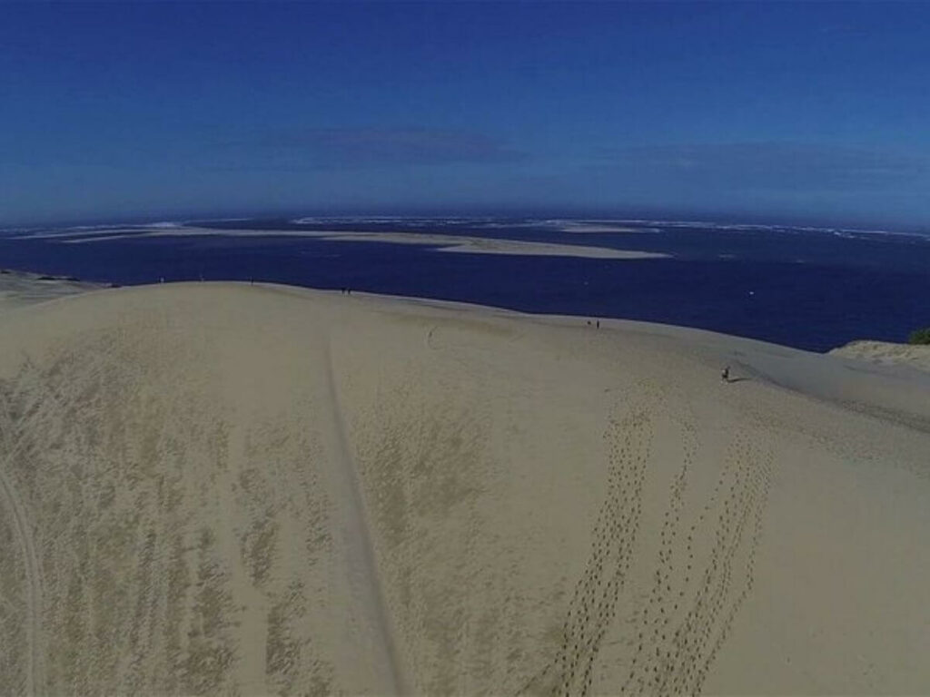 A sand dune with a blue sky behind