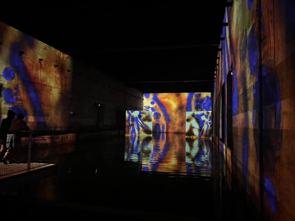 Paintings reflected into water and lit up in a submarine base in Bordeaux