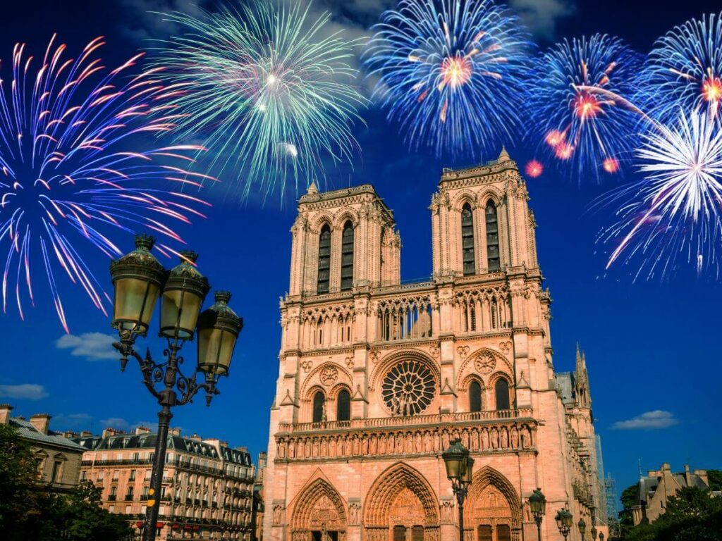 An old building in France with fireworks going off behind it.