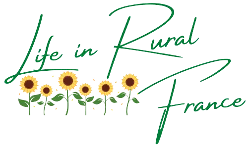 A text logo with the words Life in Rural France in green and some cartoon sunflowers as part of it