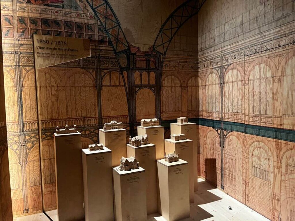 9 wooden plinths with wine exhibits as part of the cite du vin and walls covered in wine drawing