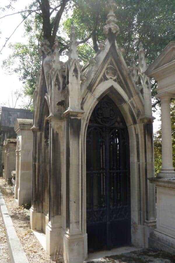 An old grave in a cemetery in Paris that looks like a mini house