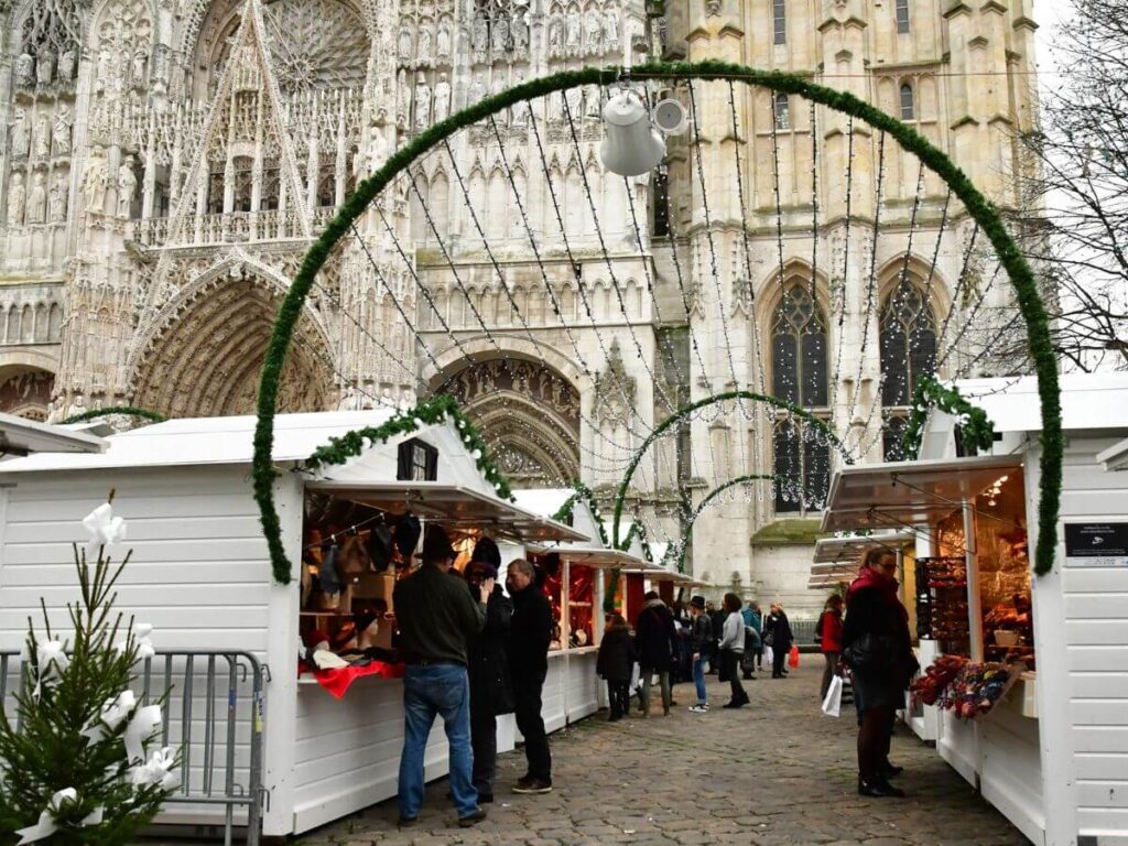 A Christmas market set up in front of an old gothic cathedral in Rouen in France