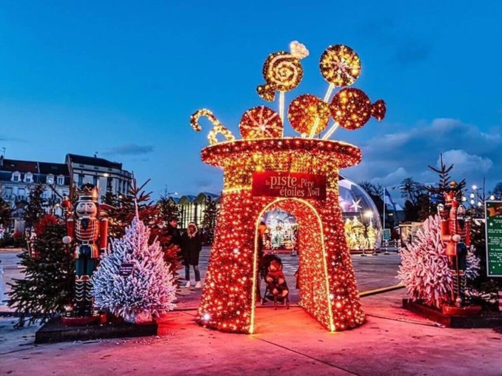 Oversized Christmas decorations and children fun fair statues at night