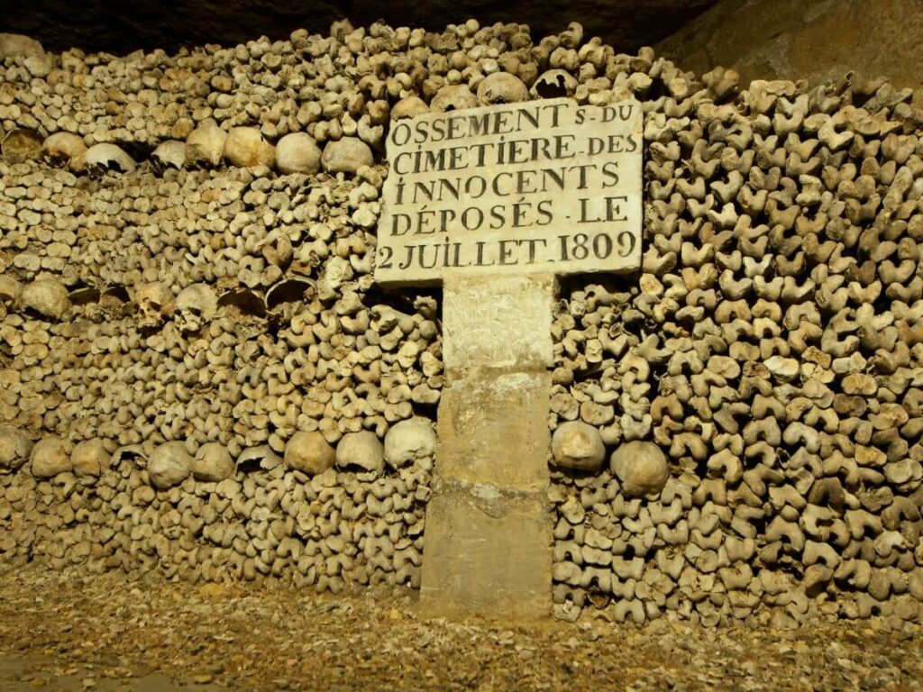 A wall of human skulls underground the streets of Paris in the catacombs