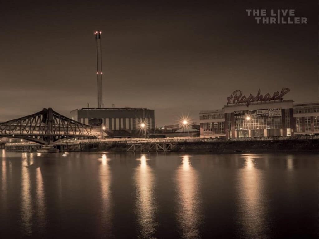 A dark evening view across the Seine River in paris with lights shining on teh water