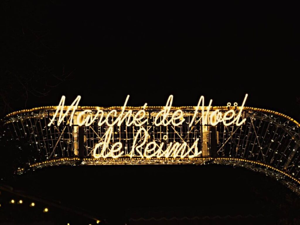 A sign saying Marche de Noels de Reims in gold lettering