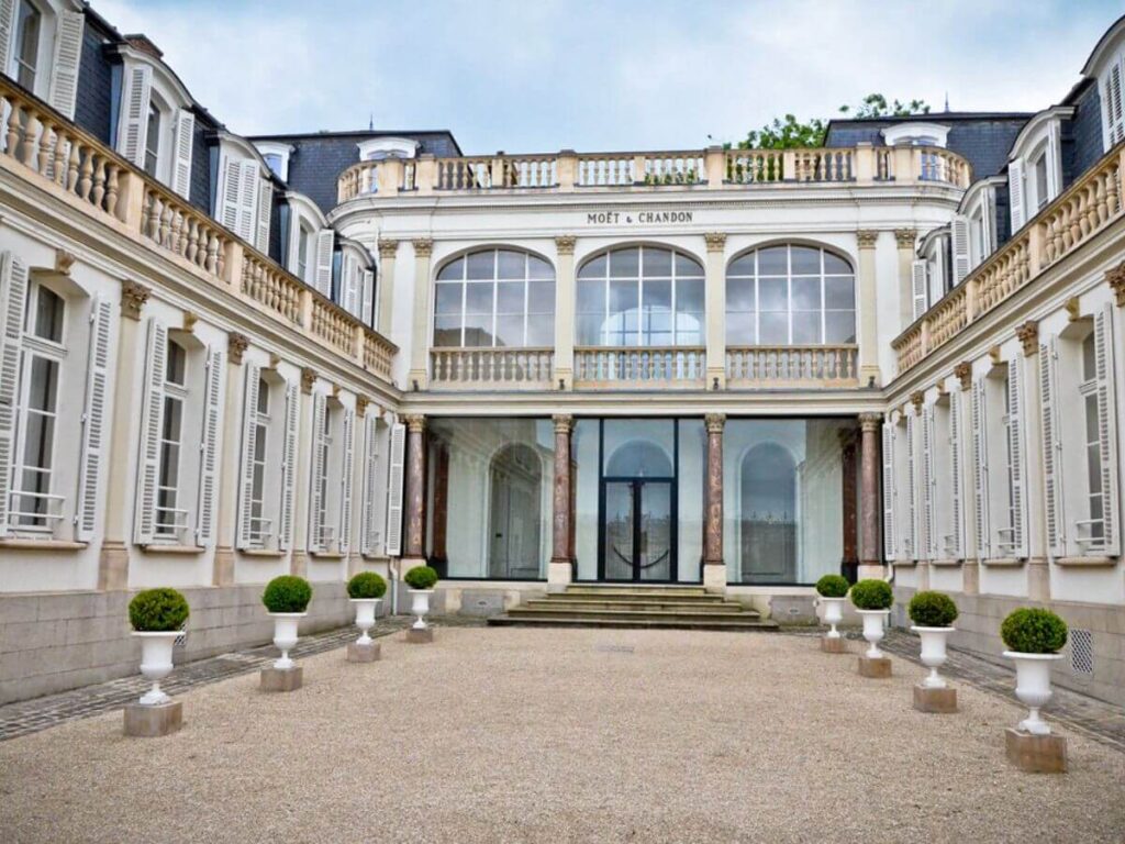 The outside of the Moet & Chandon building in France with a blue sky behind it
