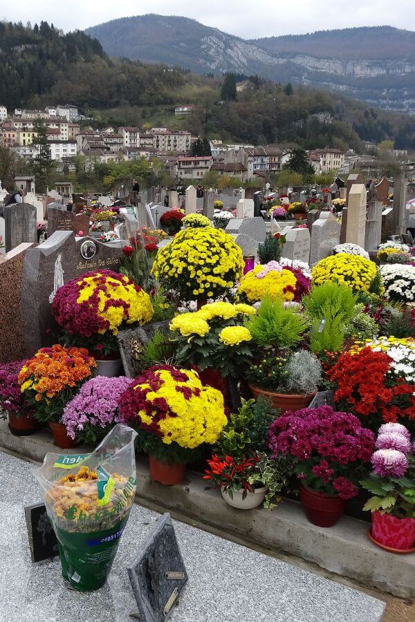 A view of a cemetery on All Saints' Day in France with lots of colourful flowers