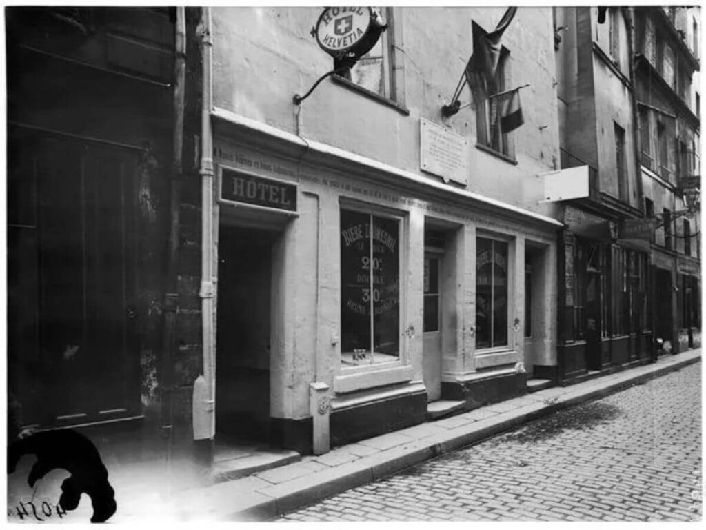 Historic black and white photo of the Maison de Nicolas Flamel, located at 51 rue de Montmorency in Paris, circa 1900, with cobblestone streets and vintage signage