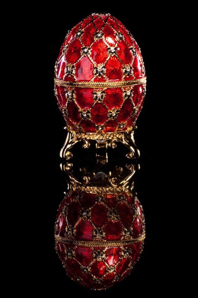 Ornate red Fabergé egg with gold detailing and gemstones, reflecting the luxurious Easter traditions associated with decorative eggs in France.