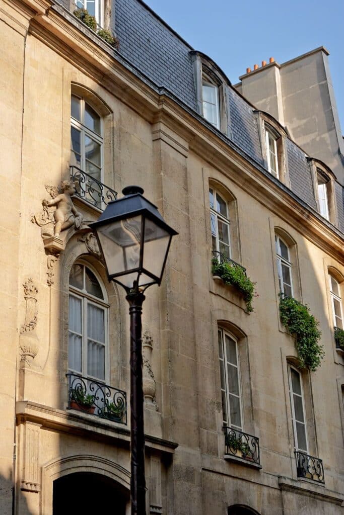 Paris building with a sculptural facade detail and a classic streetlamp.