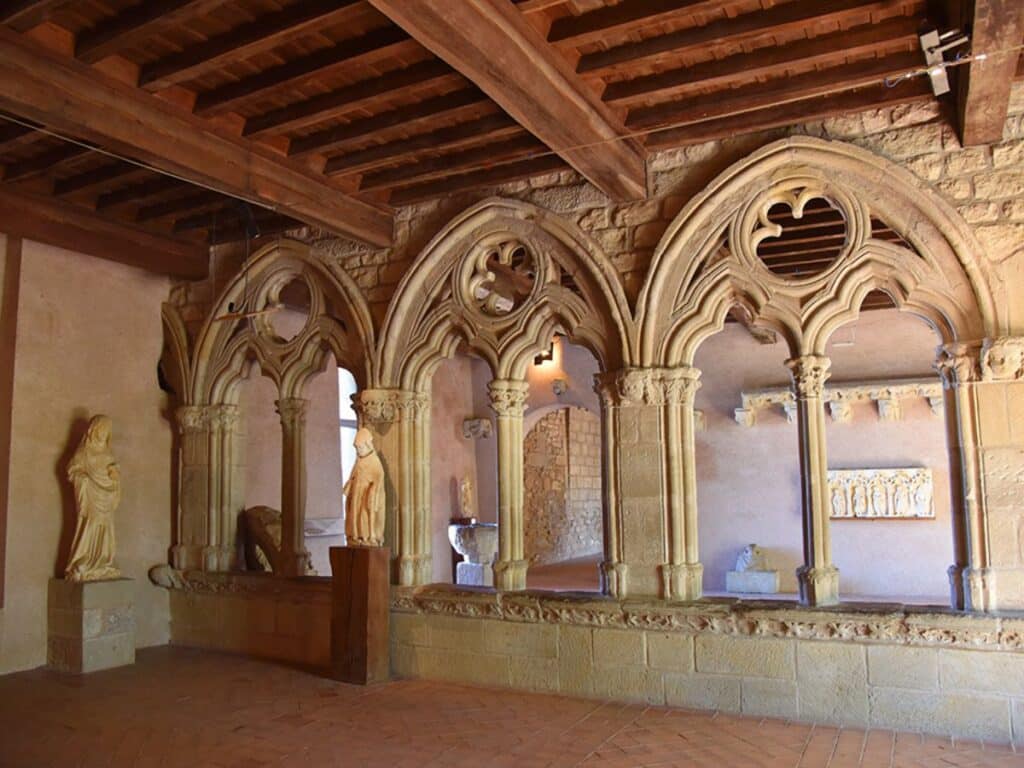 An interior view of Carcassonne Castle showcasing Gothic arches and religious statues, illustrating the architectural enhancements that echo the castle's medieval grandeur.