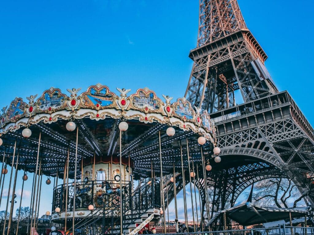 Twilight view of a Paris carousel with the Eiffel Tower towering in the background.