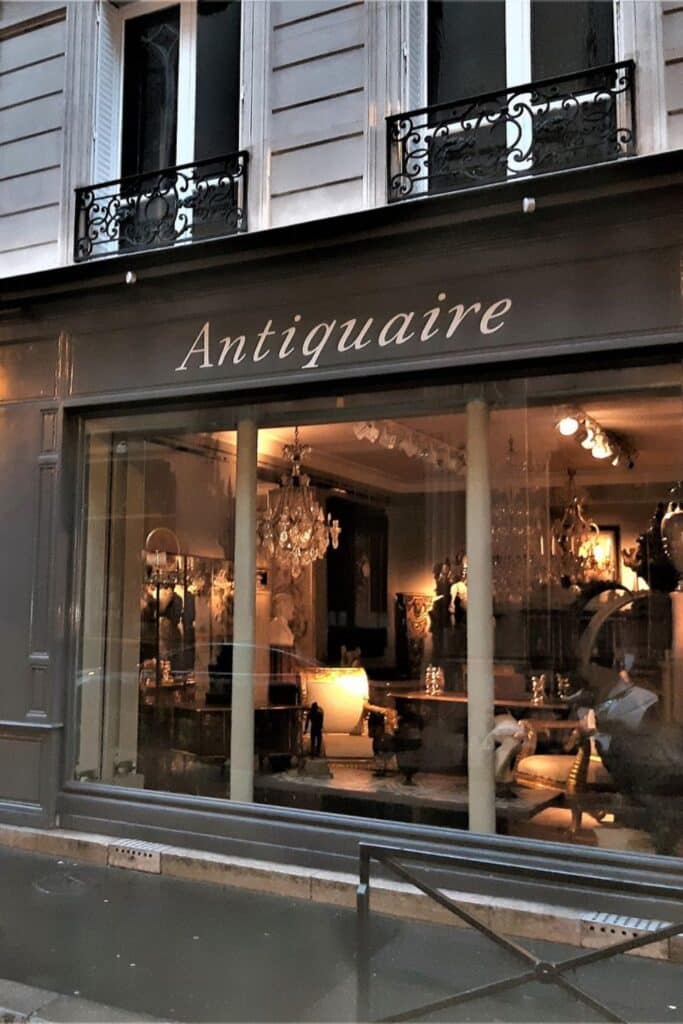 Antique shop front in Paris with elegant chandeliers.