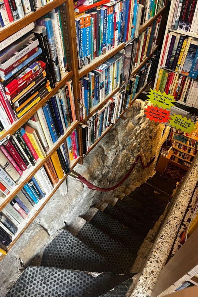 Staircase in a bookstore lined with colorful travel books and notices.