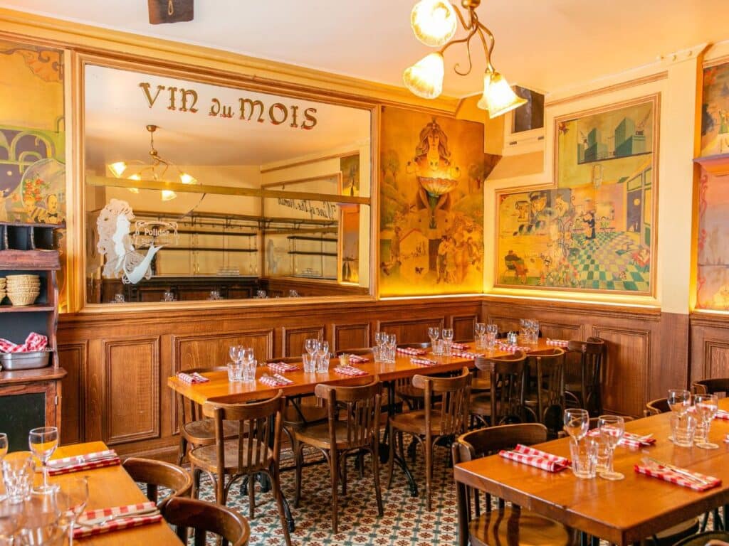 Cozy Paris bistro interior with murals and wooden decor.