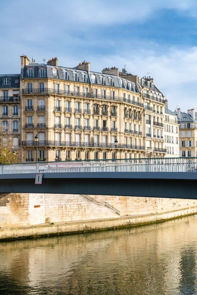 Parisian riverside apartments above a modern bridge.