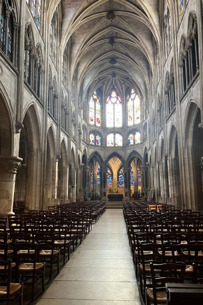Spacious Gothic church interior with vaulted ceilings and stained glass.