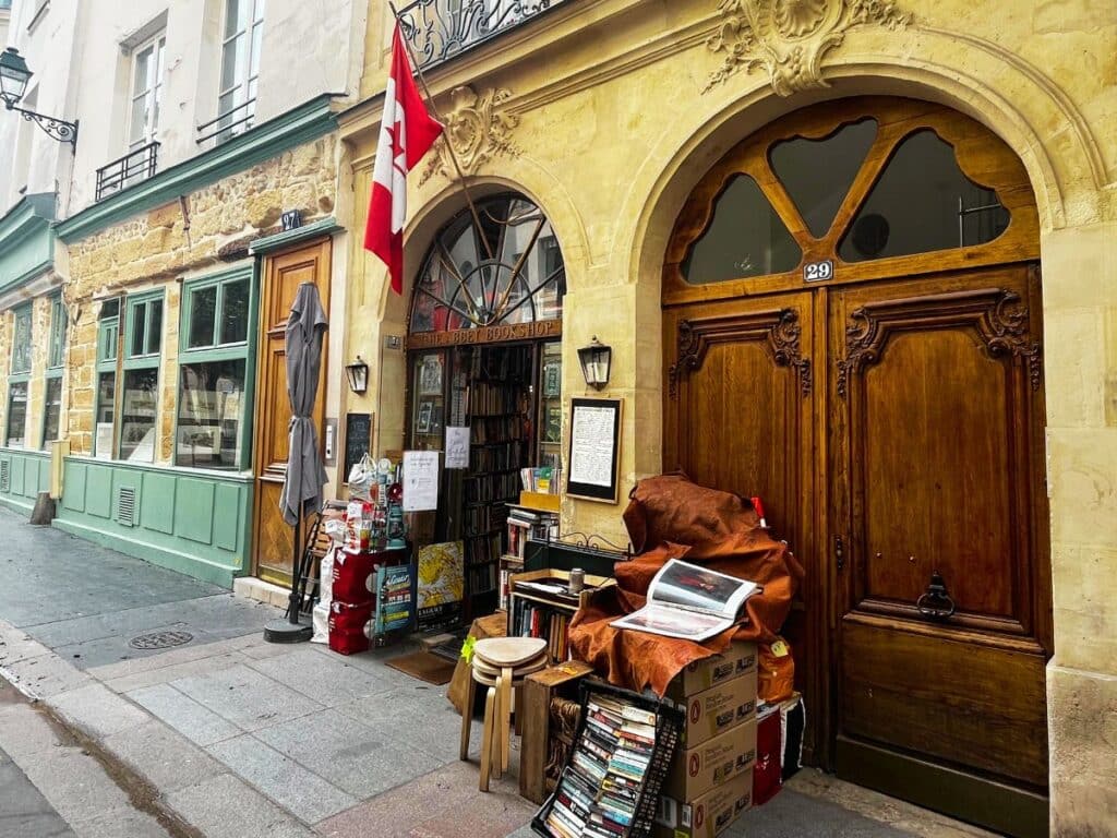 A charming bookstore with a Canadian flag and a collection of books on display outside.