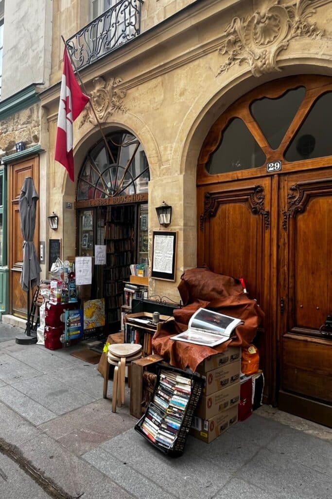 Quaint bookshop with a wooden door and a Canadian flag, surrounded by books.