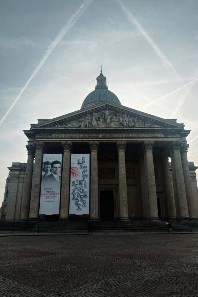 Majestic Pantheon facade under a sky crossed with contrails.